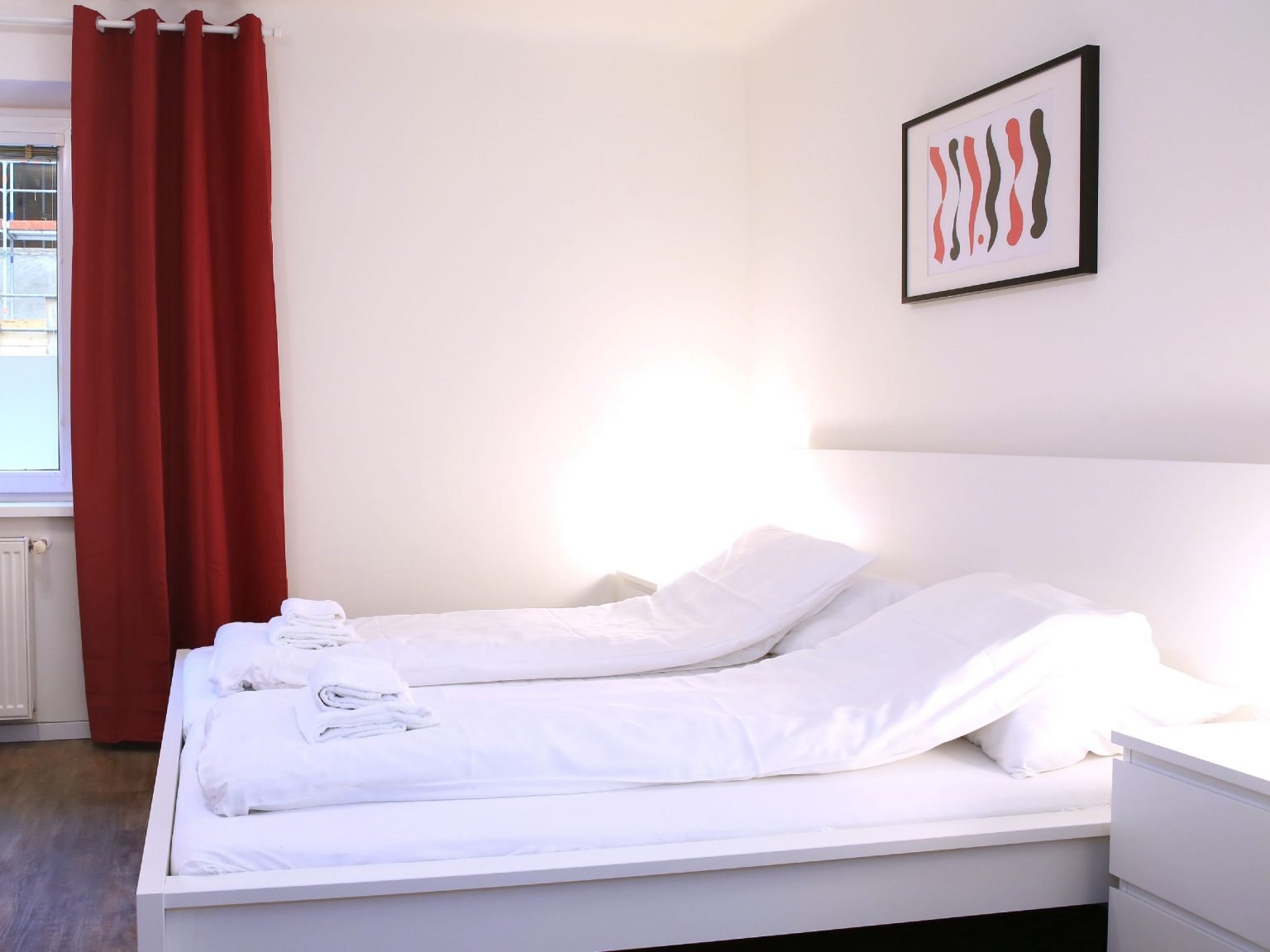 Modernes, weißes Schlafzimmer mit roten Akzenten