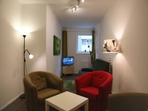 Moderne Wohnung mit bunten Möbeln und einem kleinen Fernseher in der Ecke
