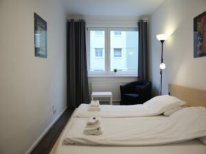 Modernes Schlafzimmer mit blauem Stuhl und hoher Lampe