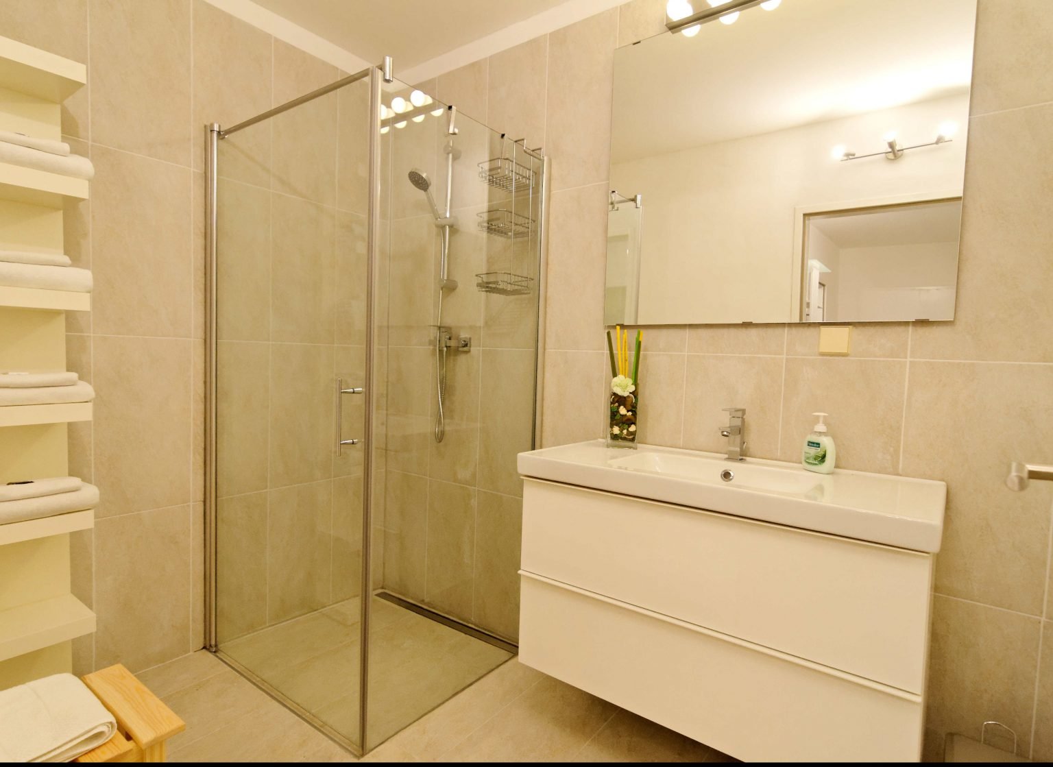 Modernes Badezimmer mit Glasdusche, großem Spiegel und neuer Einrichtung