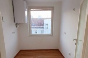 Leerer, weißer Raum mit einem Fenster und Holzboden