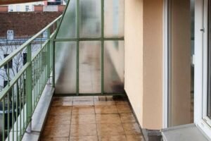 Kleiner Balkon mit grünem Geländer