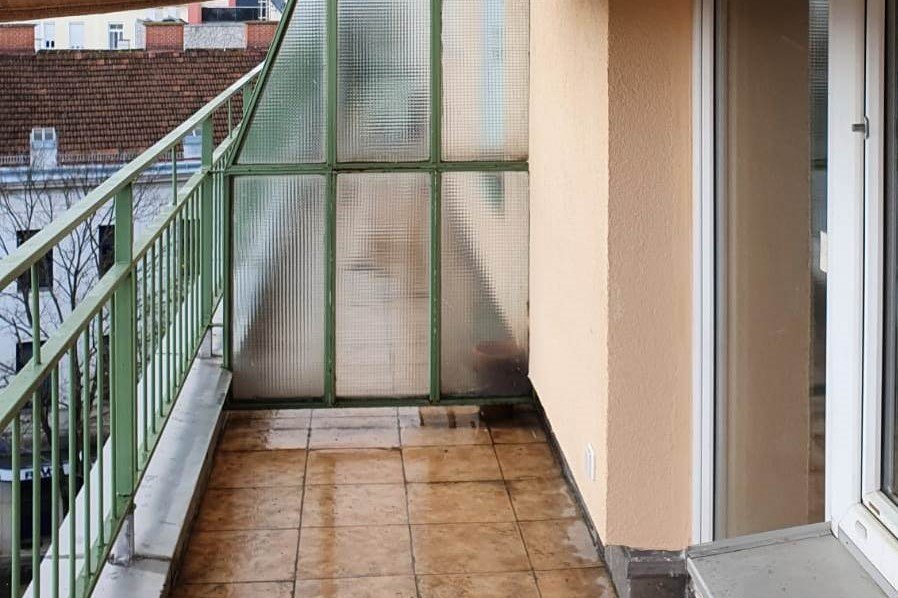 Kleiner Balkon mit grünem Geländer