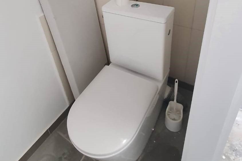 Weiße Toilette mit weißem Klopinsel