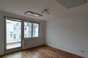 Moderne, leerstehende Wohnung mit weißen Wänden und neuem Holzboden