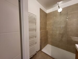 Modernes Badezimmer mit großen Fliesen und Heizkörper