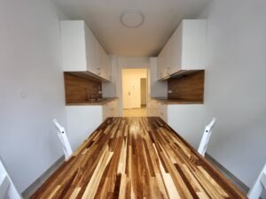 Moderne, weiße Küche mit großer Holzplatte und Essbereich