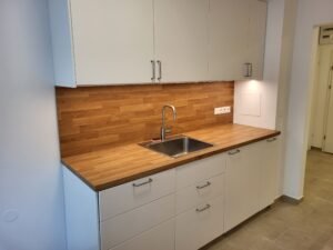 Moderne, weiße Küche mit Holzplatte