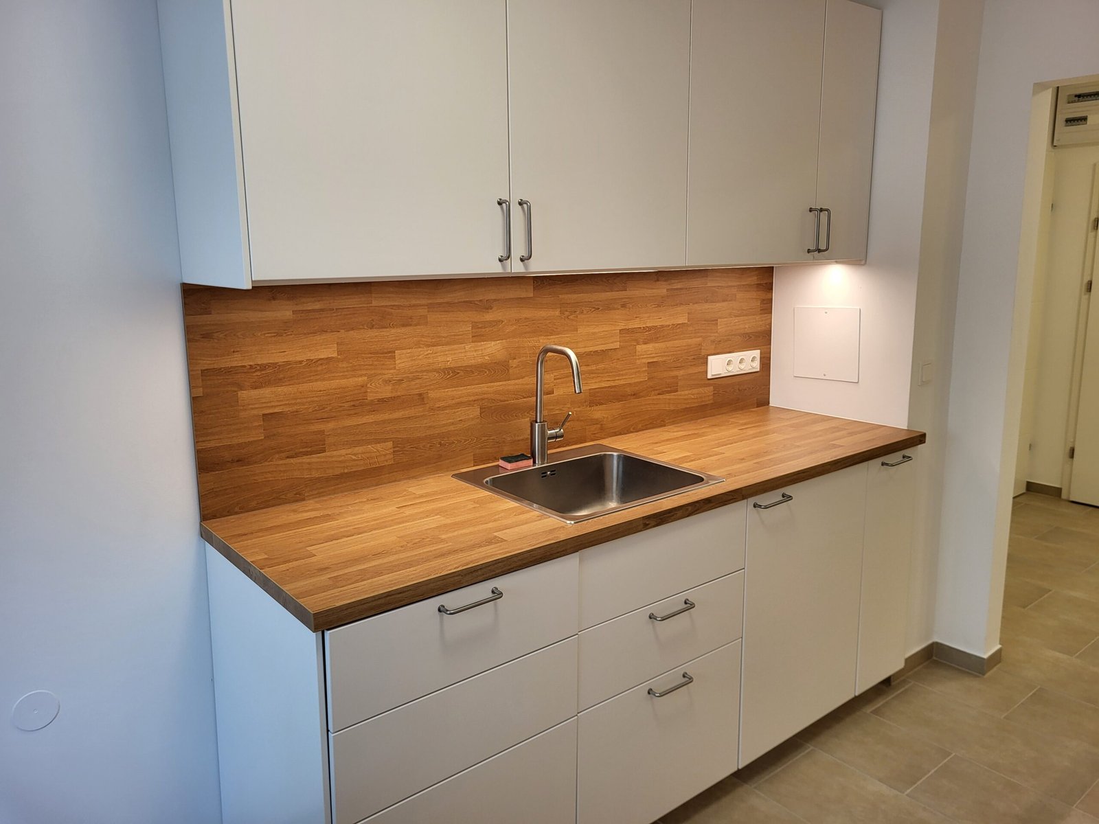 Moderne, weiße Küche mit Holzplatte