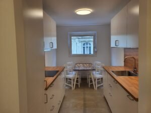 Moderne, weiße Küche mit Holzplatte und Essbereich